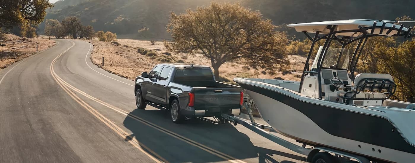 Rear of a black 2025 Toyota Tundra towing a boat.