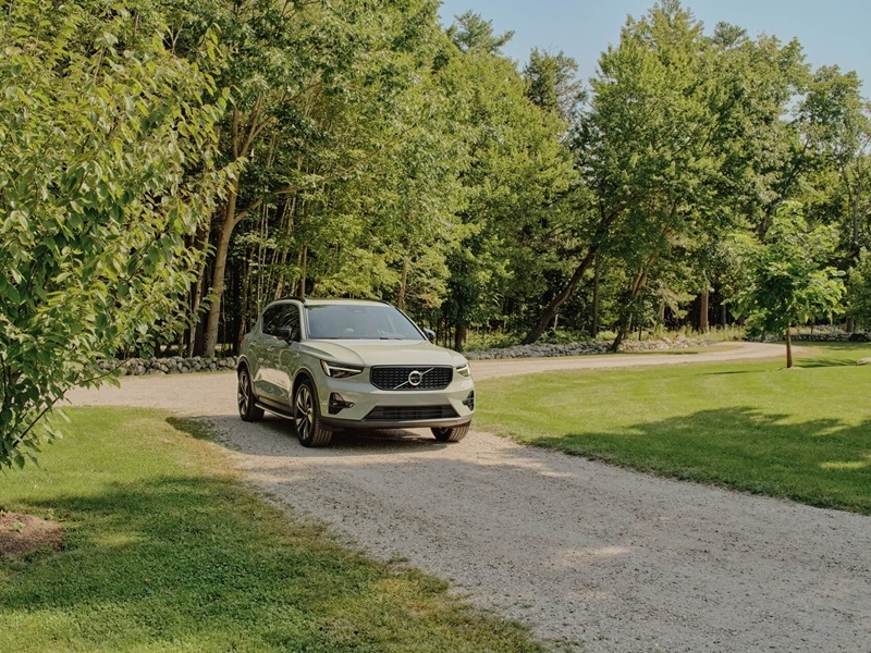 Volvo XC40 parked at entrance of dirt road driveway on a sunny day