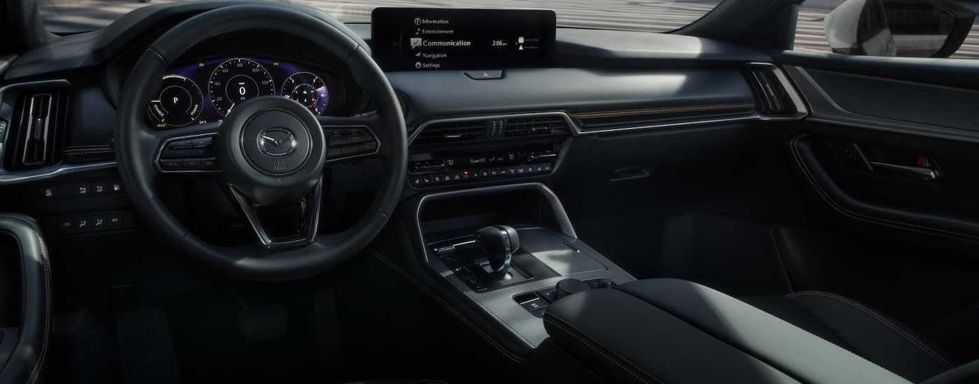 Steering wheel and dashboard inside a 2026 Mazda CX-90 Hybrid.