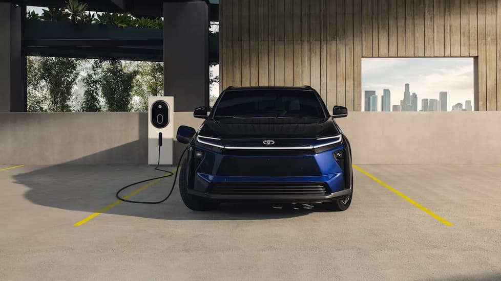 Blue 2026 Toyota bZ plugged in at a charging station.