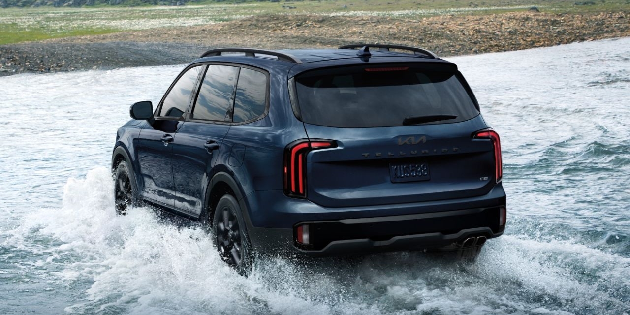Rear of a blue 2025 Kia Telluride SX Prestige X-Line fording a river.