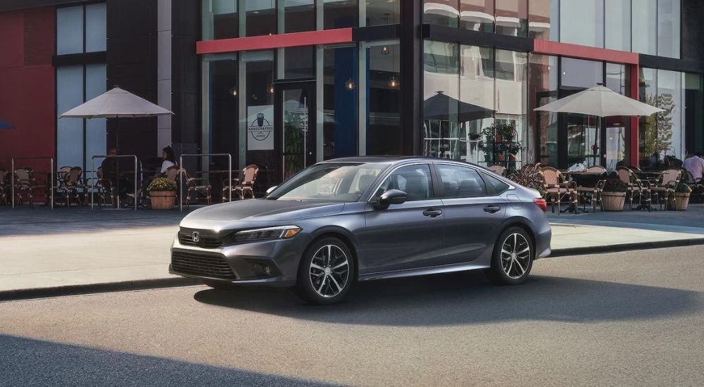 Grey 2023 Honda Civic driving to a used car dealer near Kingston