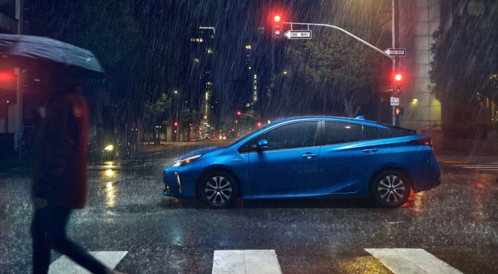 Blue 2021 Toyota Prius in an intersection during a rainstorm