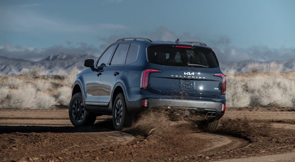 Rear of a blue 2025 Kia Telluride driving off-road.