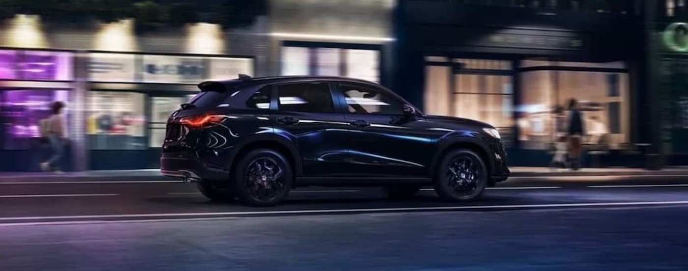 A black 2023 Honda HR-V Sport driving at night.