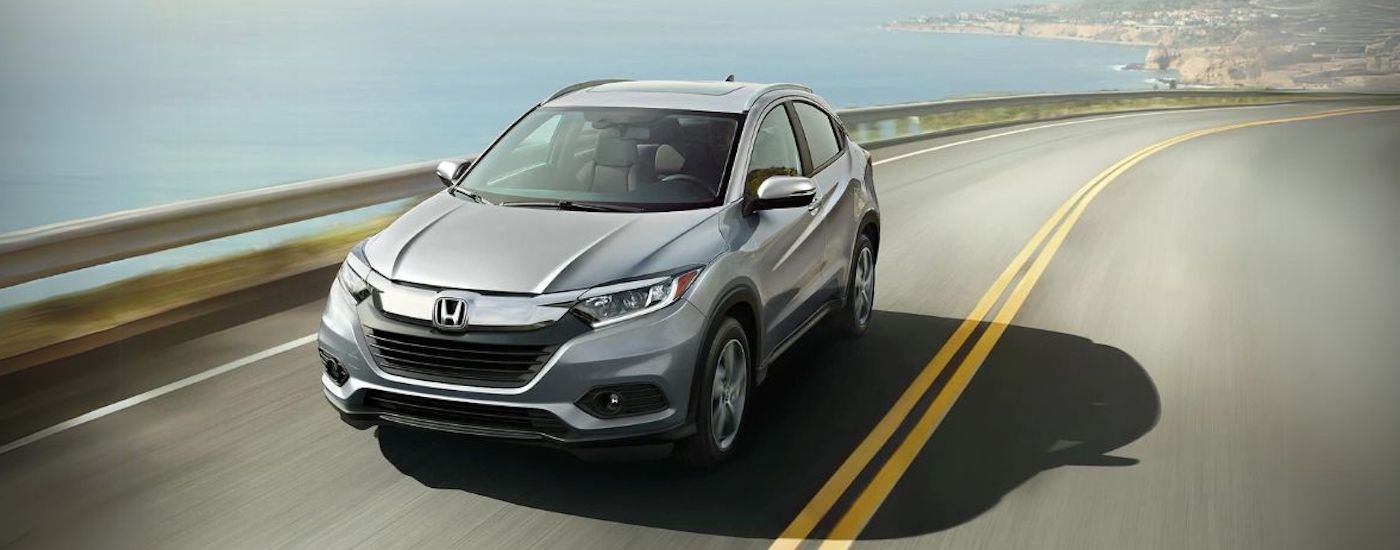 Grey 2021 Honda HR-V driving down a road.
