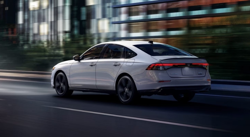 A white 2025 Honda Accord driving in a city.