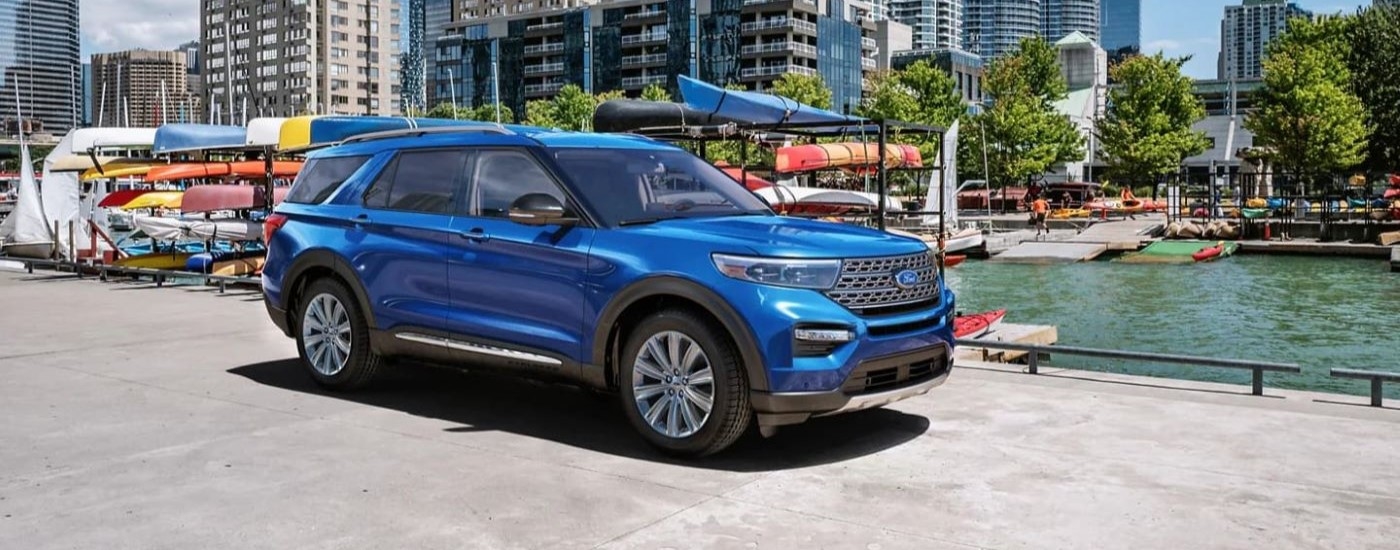 Blue 2024 Ford Explorer parked near a dock.