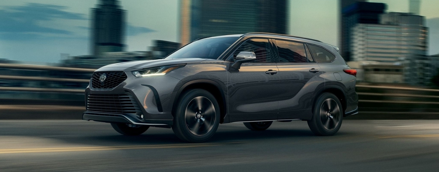 Grey 2022 Toyota Highlander for sale near The Bronx driving on a city street