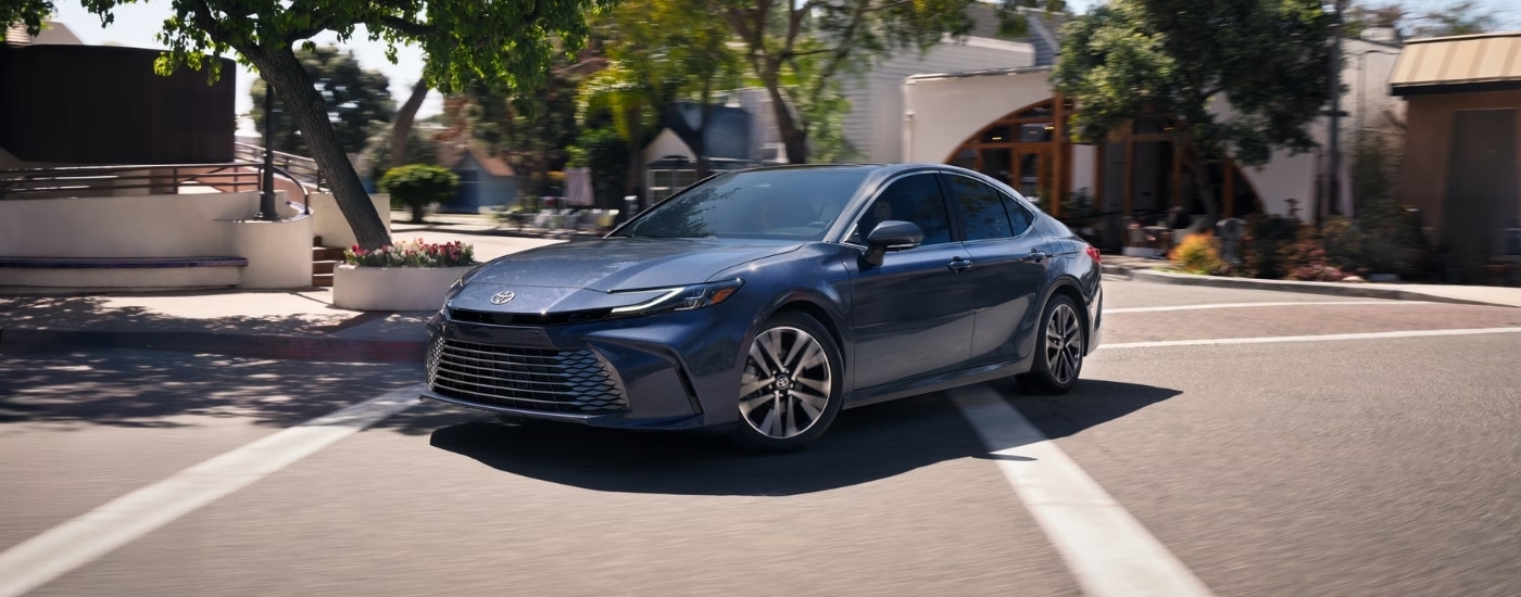 Blue 2026 Toyota Camry XLE driving through an intersection