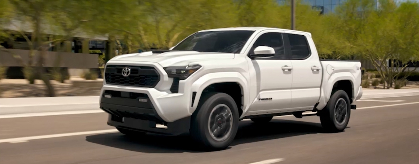 White 2025 Toyota Tacoma for sale near The Bronx driving on a city street