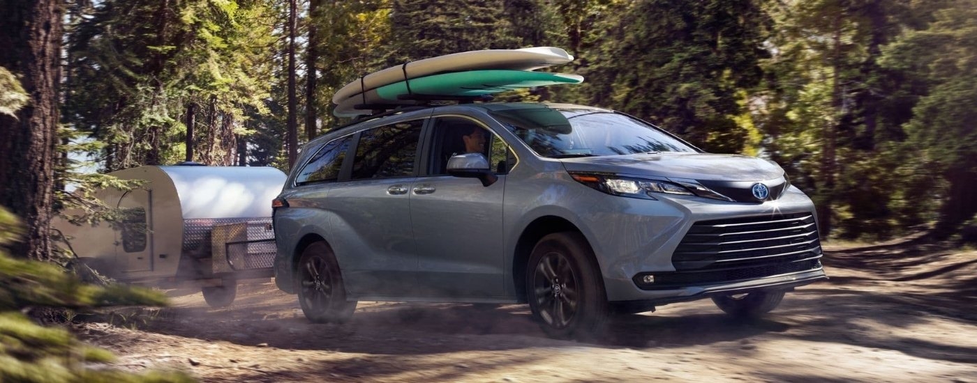 Grey 2024 Toyota Sienna Woodland Edition towing a teardrop camper