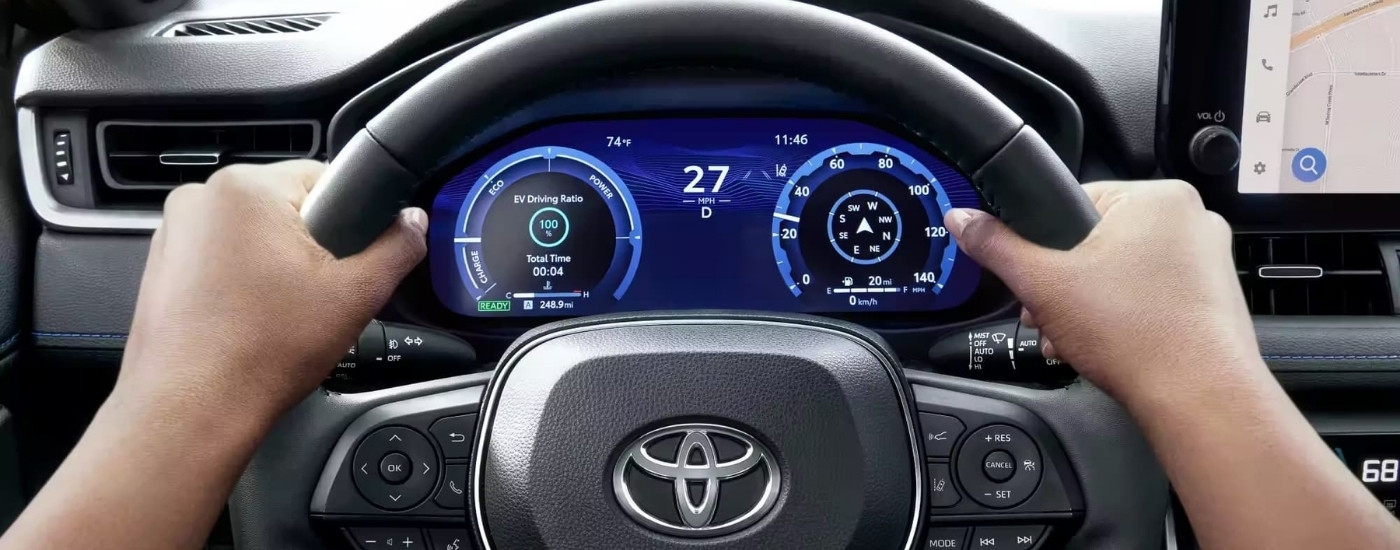 Person steering a 2023 used Toyota RAV4 for sale near Greenfield