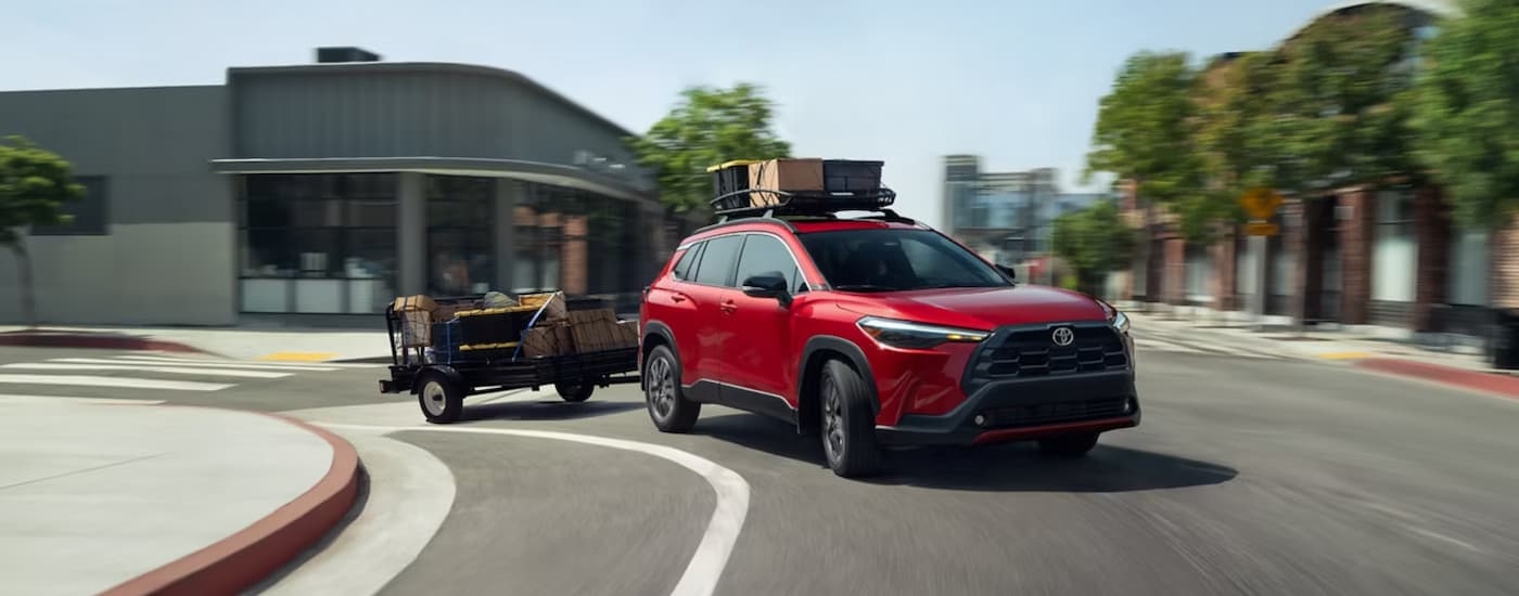 Red 2025 Toyota Corolla Cross for sale driving on a city street