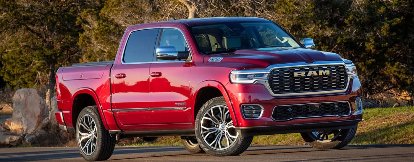 Red 2025 Ram 1500 driving down a road.