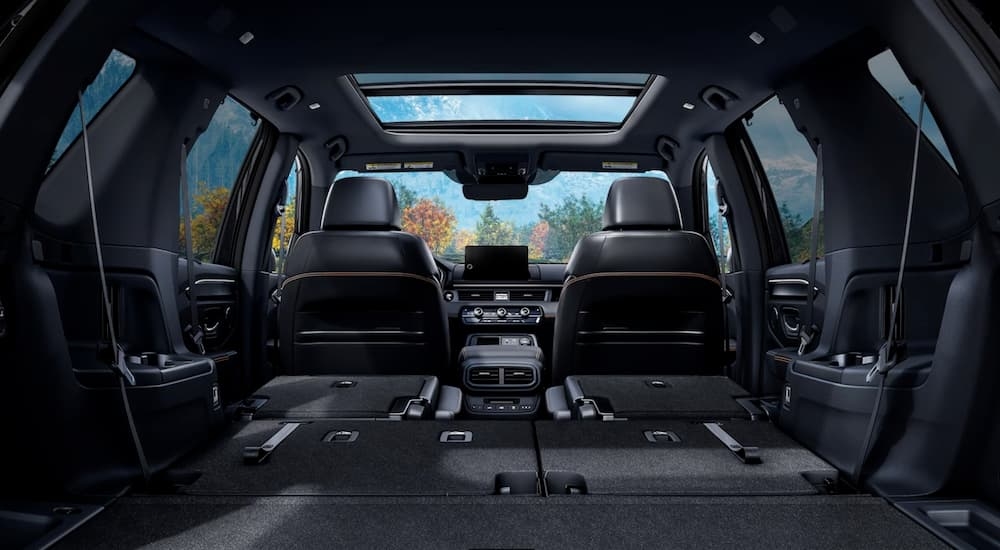 Rear view of the interior of a 2025 Honda Pilot Black Edition with the back seats folded down.