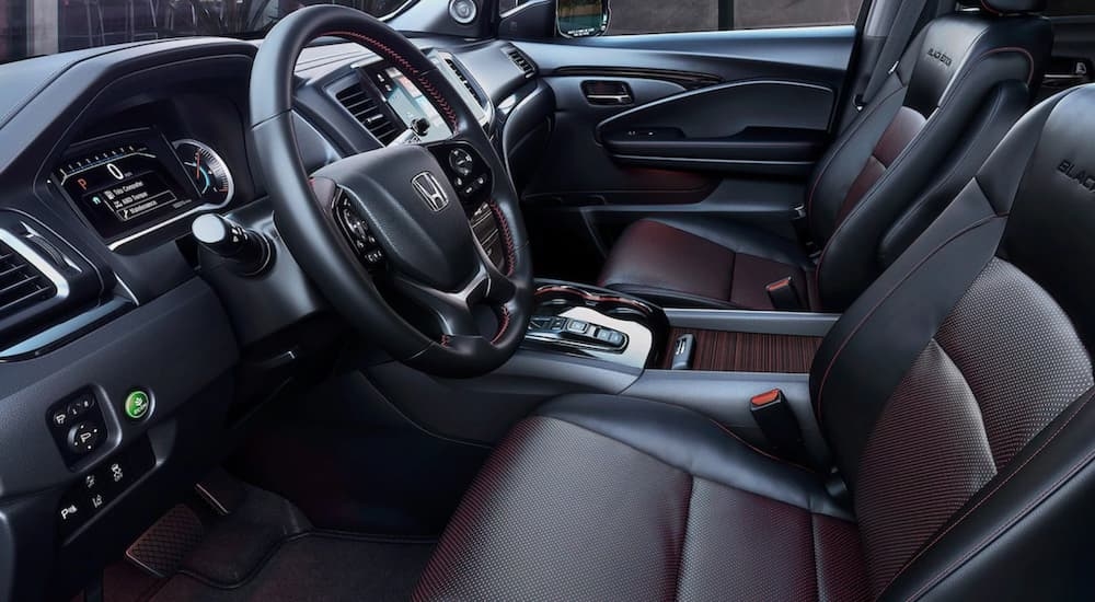 Black and red front seats, steering wheel and dashboard inside a 2025 Honda Pilot Black Edition.