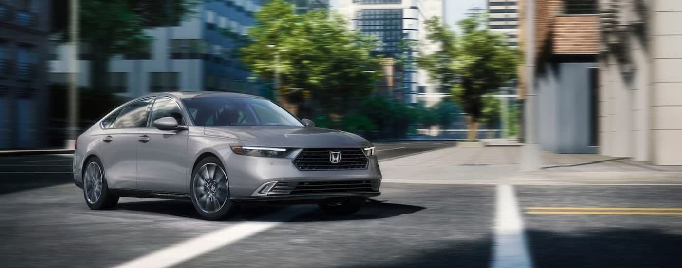 A silver 2025 Honda Accord driving in a city.