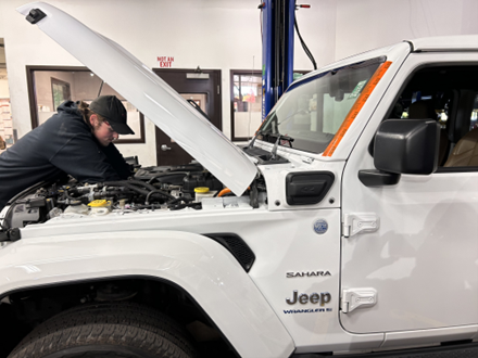 An expert technician at Planet making a service repair to a Jeep.