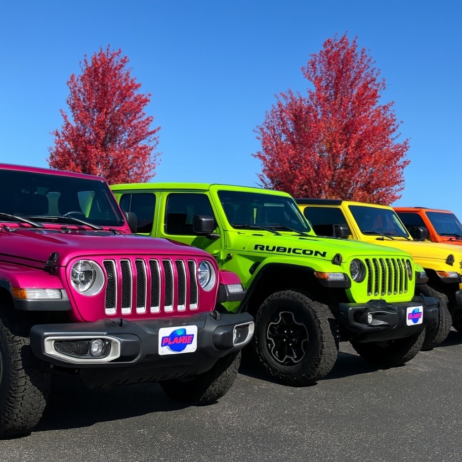 A row of colorful Jeep Wranglers that have had aluminum corrosion repairs made under warranty at Planet Jeep.