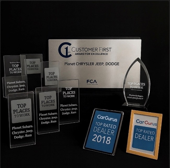 Multiple trophies shown from Boston Globe Top Places to work, Customer First Award for Excellence, and CarGurus top rated dealer award