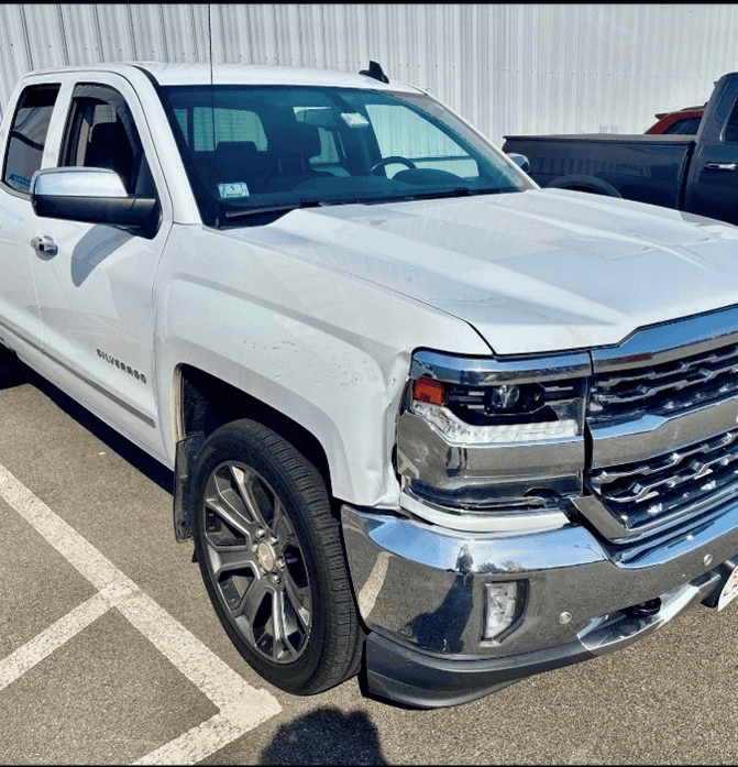 A damaged GMC truck before Planet's experts repair the body damage
