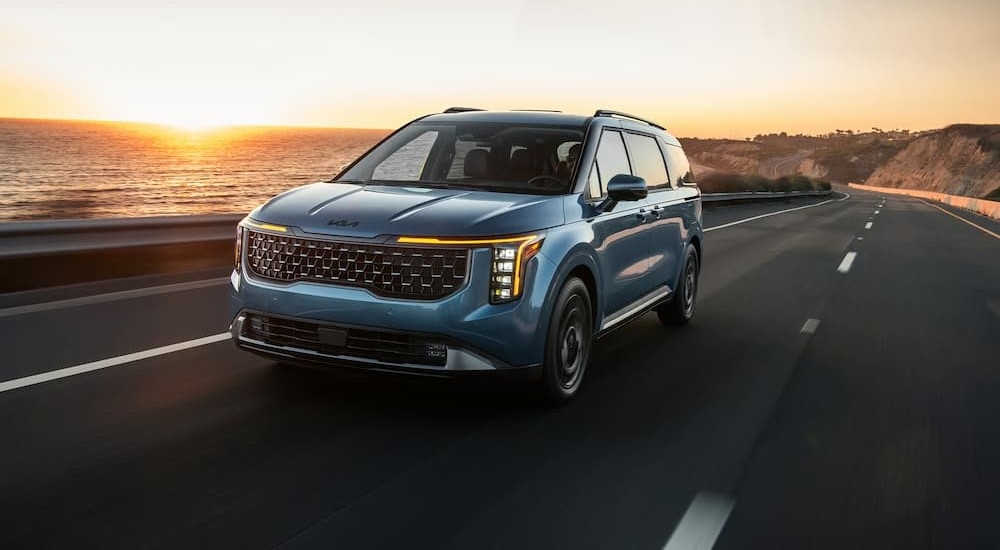 A blue 2026 Kia Carnival driving to Kia dealer near Katy.