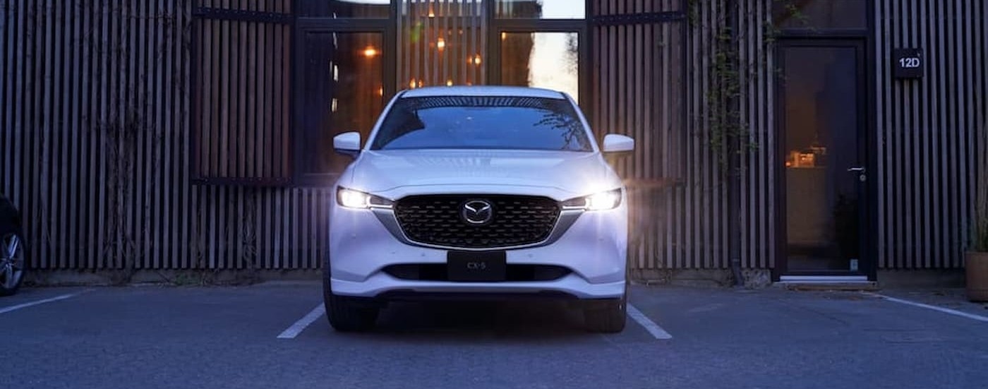 A white 2023 Mazda CX-5 parked near a used Mazda for sale near Doral.