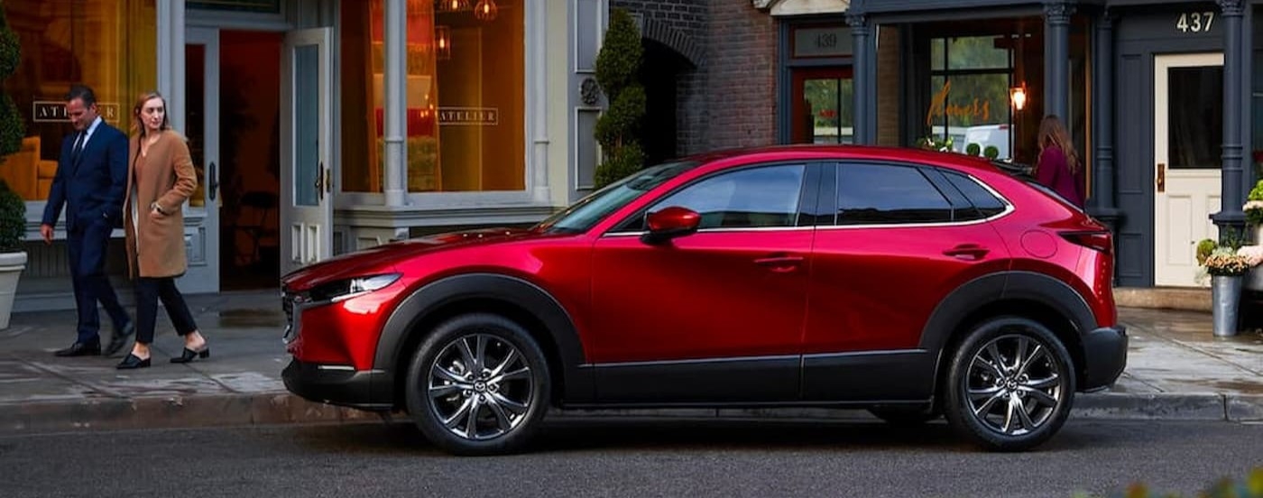 A red 2023 Mazda CX-30 parked near a used Mazda for sale near Coral Gables.
