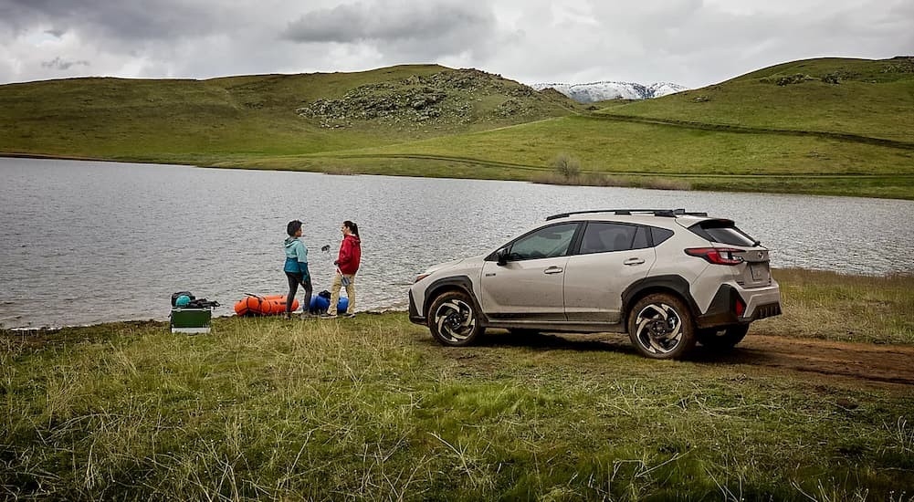 A tan 2026 Subaru Crosstrek Hybrid parked near a lake.