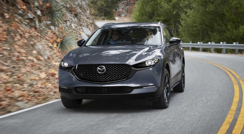A gray 2025 Mazda CX-50 driving on a highway.