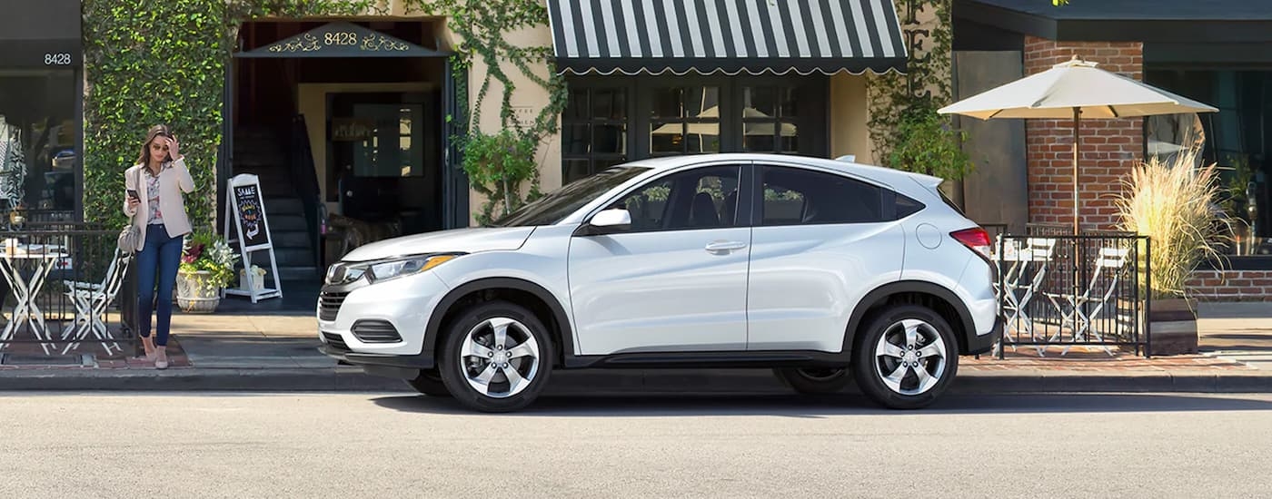 Side of a white 2020 Honda HR-V parked by a curb.
