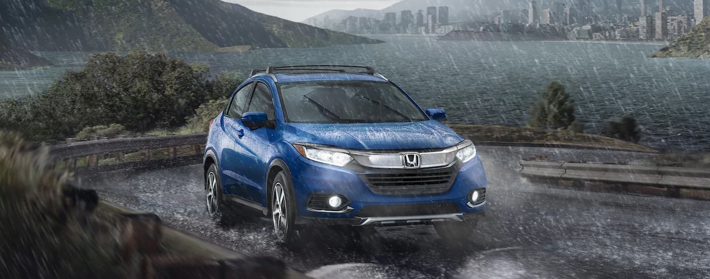 Used blue 2022 Honda HR-V for sale near Tenafly driving down a bridge.