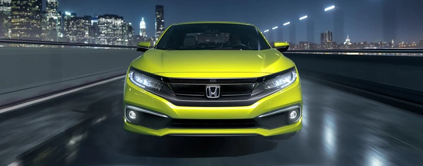 Front a yellow used 2019 Honda Civic for sale near Tenafly driving down an open road.