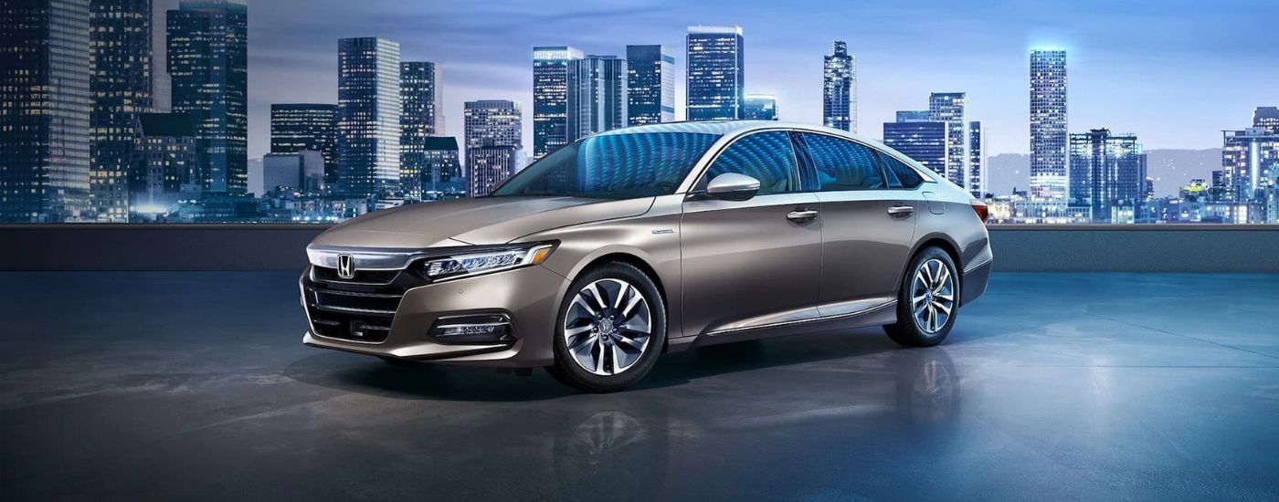 Beige 2018 Honda Accord Hybrid parked near a city.