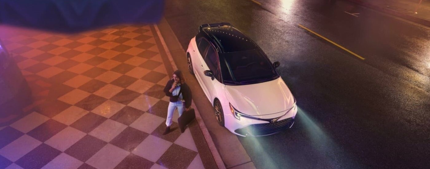 High view of a white 2026 Toyota Corolla parked by a curb.