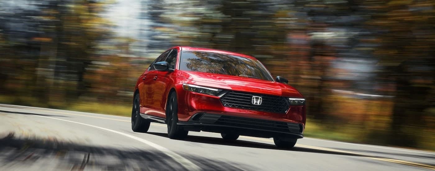 A red 2025 Honda Accord driving on a highway.