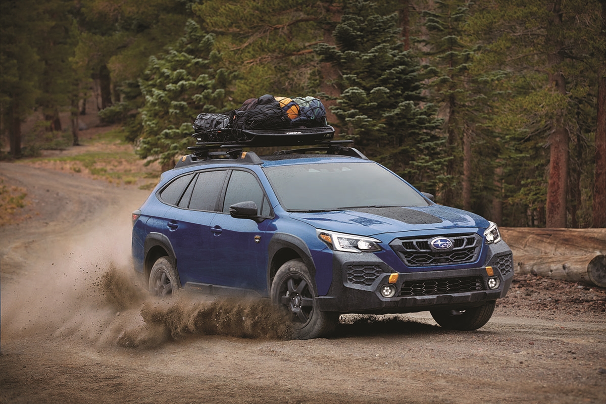 Subaru driving down dirt road