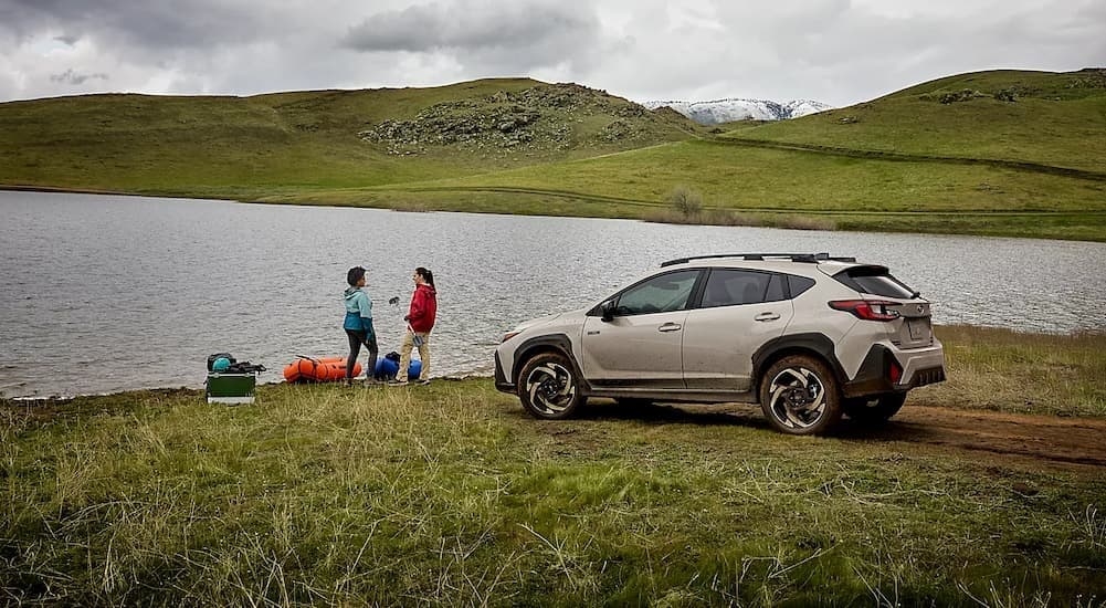 A tan 2026 Subaru Crosstrek parked near a lake.