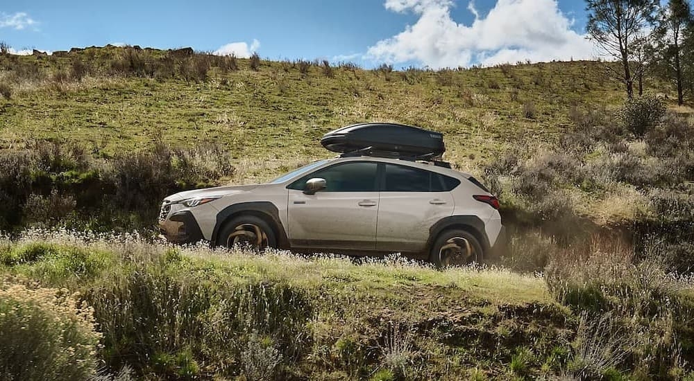 A tan 2026 Subaru Crosstrek Hybrid for sale off-roading.