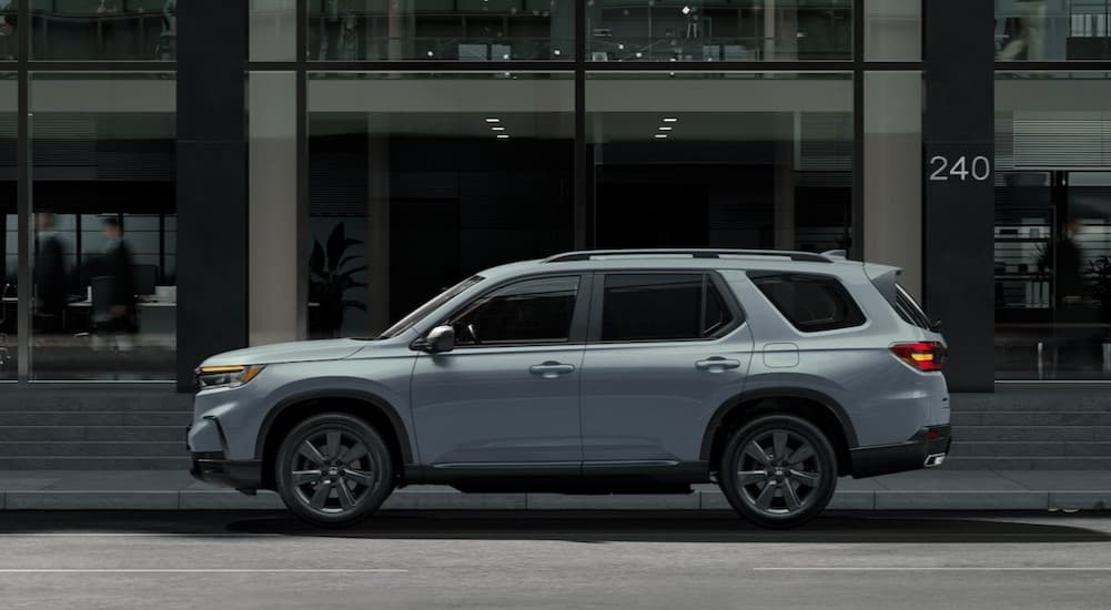 A gray 2025 Honda Pilot parked in a city.