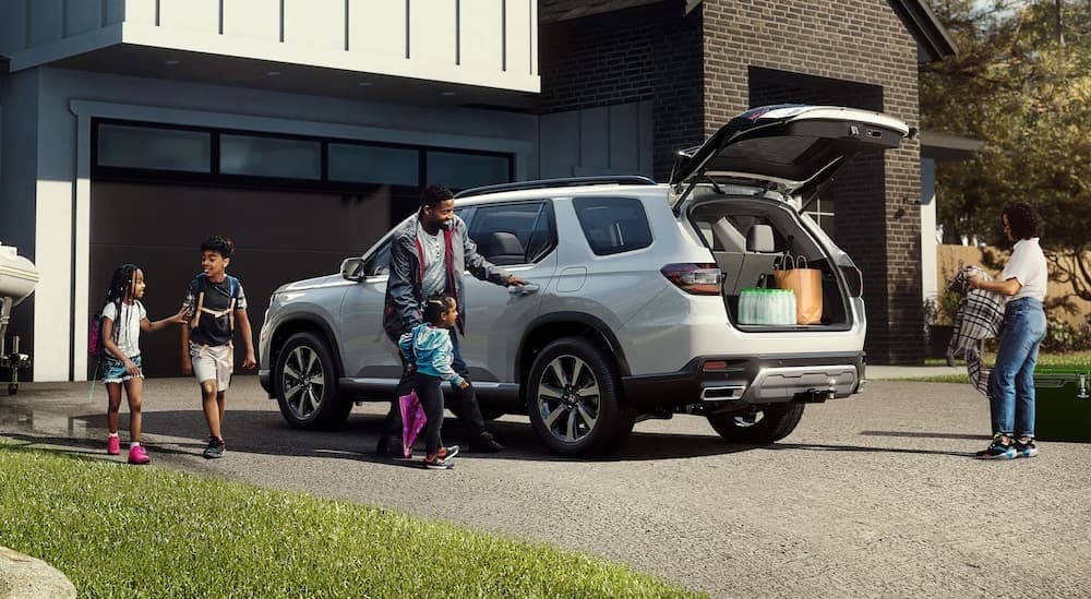 A white 2025 Honda Pilot parked on a driveway.