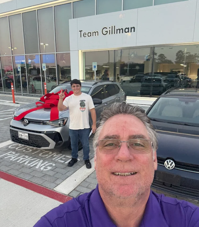 Smiling Customer with Sales Staff at Team Gillman Volkswagen of Kingwood