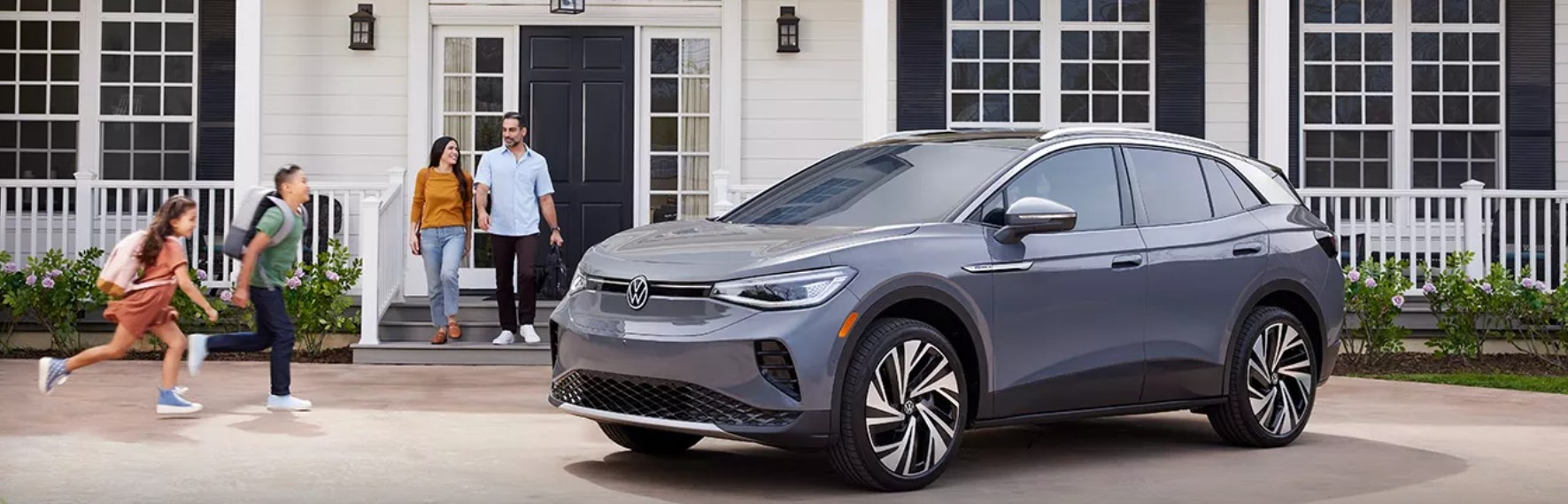Exterior of New Volkswagen ID.4 with Happy Family in Front of Home at Team Gillman Volkswagen of Kingwood