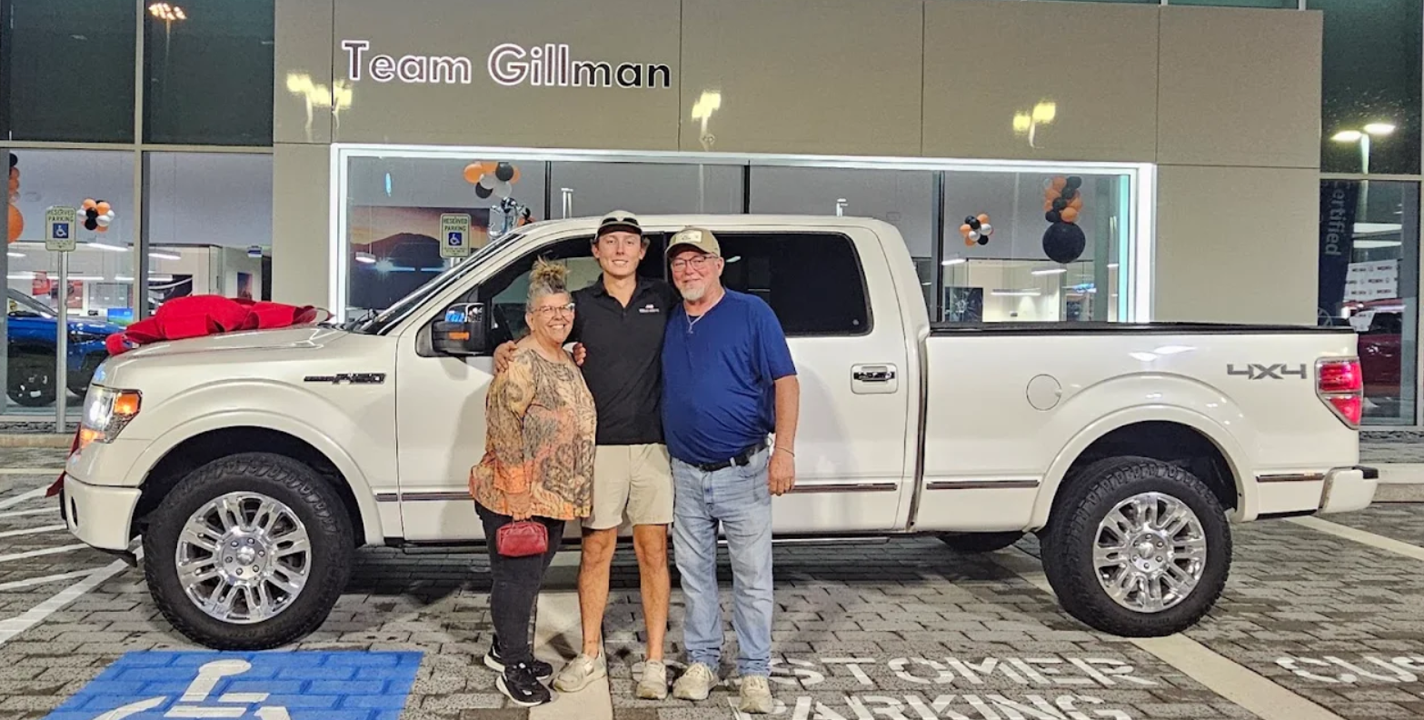 Car shoppers in front of a new truck at Team Gillman Volkswagen