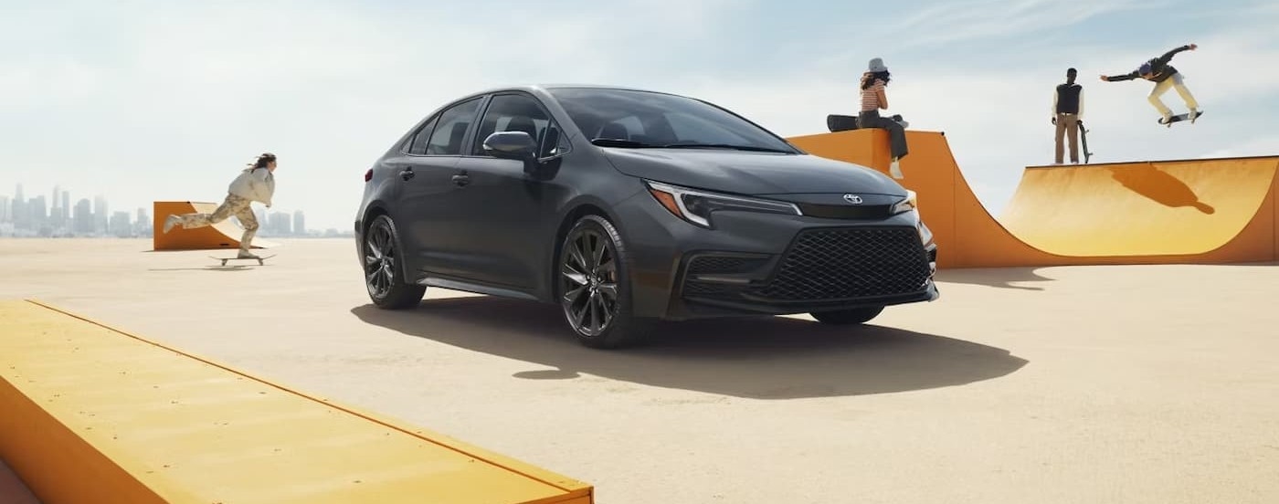 A gray 2026 Toyota Corolla parked near skateboarders.