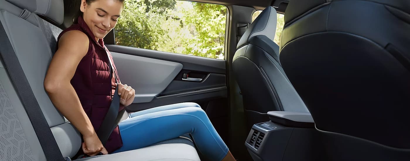 Woman bucklingthe seat belt in the back of a 2026 Subaru Solterra