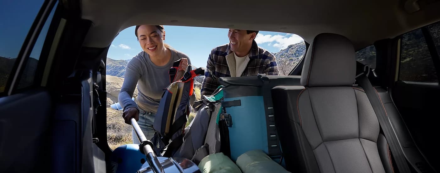 Two people putting kayaking gear into the back of a 2026 Subaru Crosstrek Hybrid