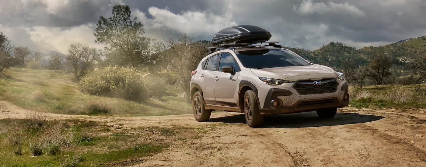 White 2026 Subaru Crosstrek Hybrid off-roading on a dusty trail