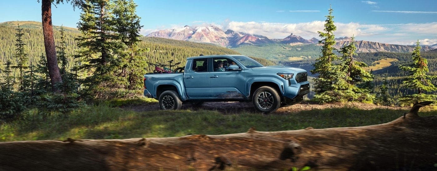 Blue 2026 Toyota Tacoma TRD Sport driving on a trail